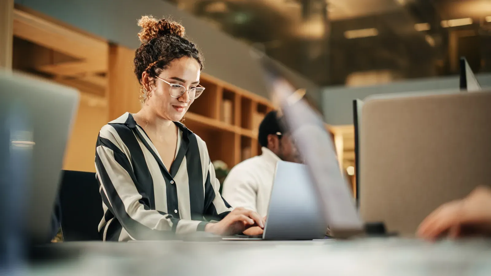 A professional working on a laptop in a bright office