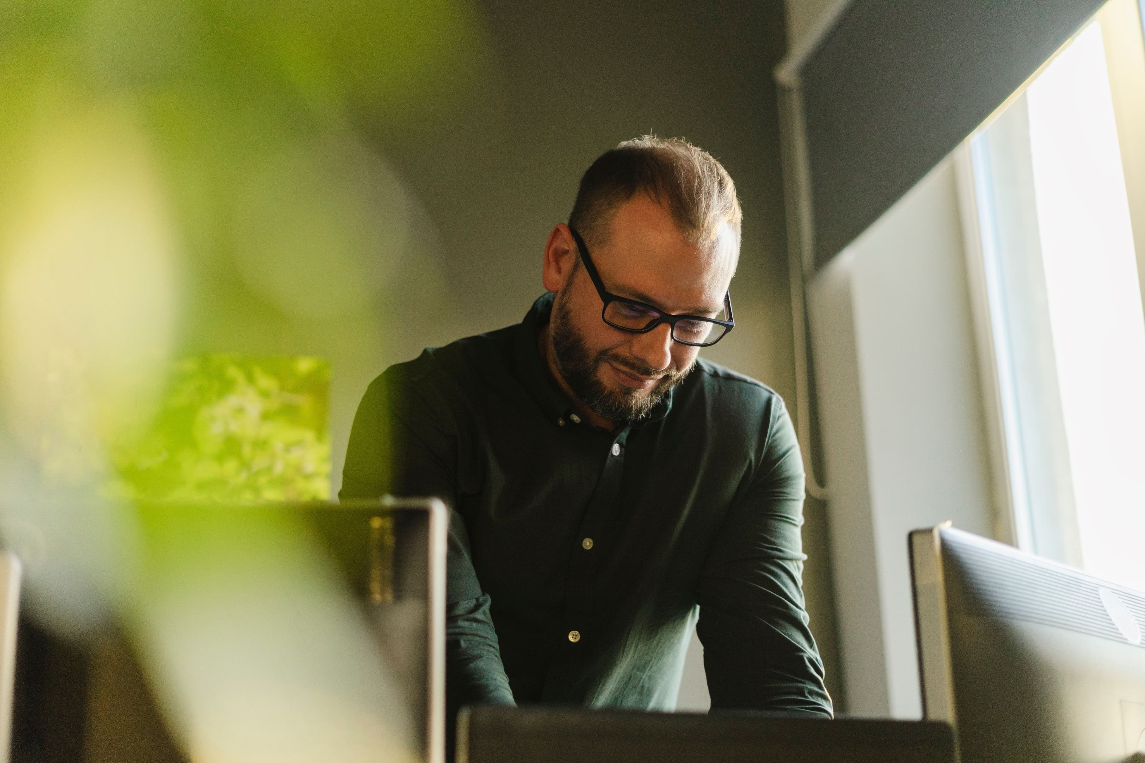 Talent specialist working at a laptop in a bright, plant-filled office
