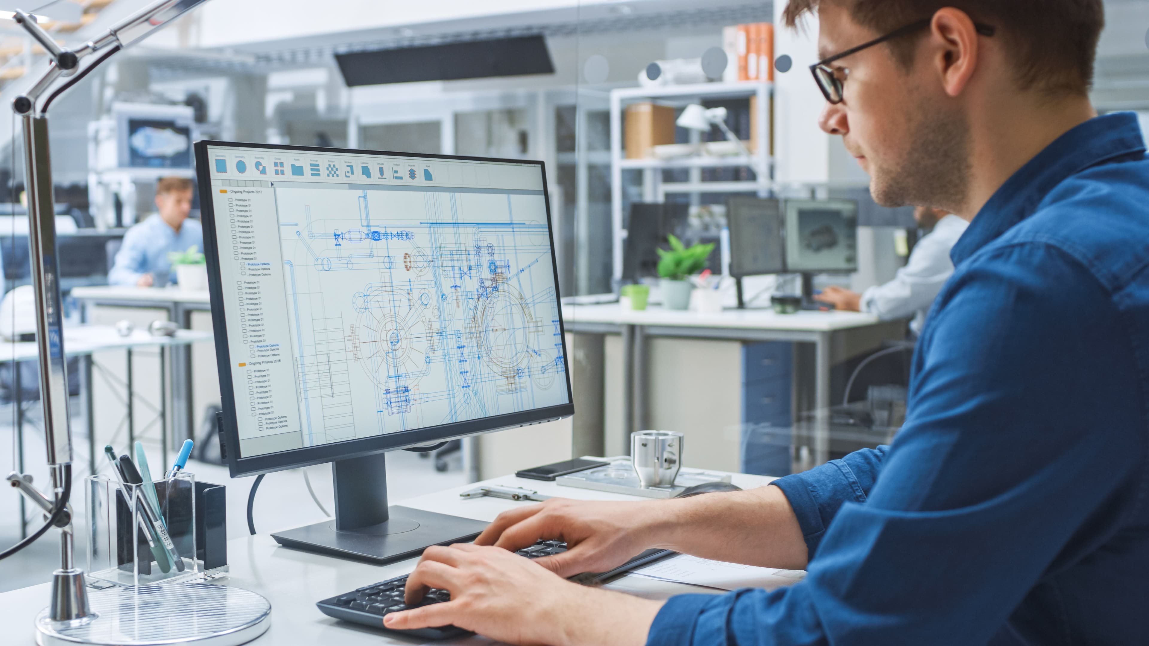 An engineer reviewing a technical design on a desktop monitor.